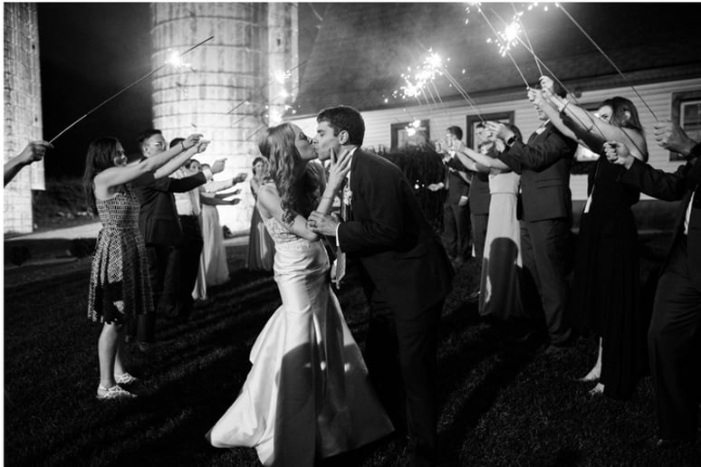 Bride and groom kissing during a sparkler send-off.